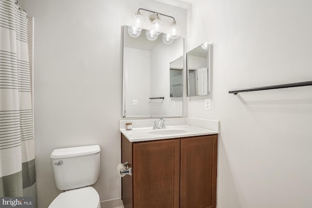 bathroom featuring vanity, walk in shower, and toilet