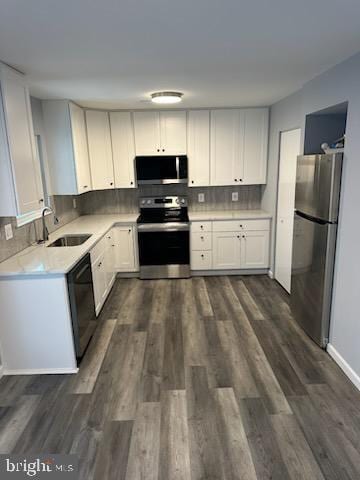 kitchen featuring stainless steel appliances, sink, white cabinets, and decorative backsplash