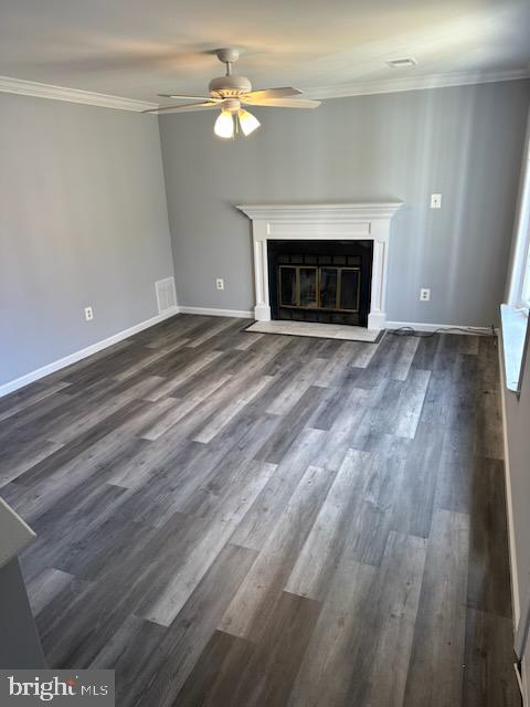 unfurnished living room featuring crown molding, dark wood-type flooring, and ceiling fan