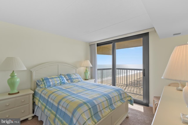 carpeted bedroom with floor to ceiling windows, a water view, and access to exterior