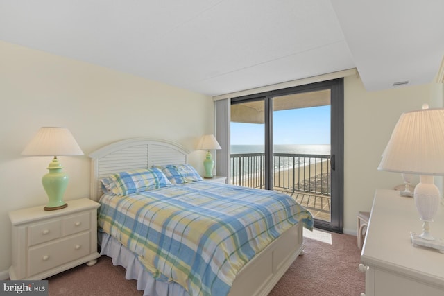 carpeted bedroom featuring a water view, floor to ceiling windows, and access to exterior