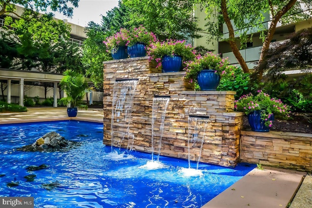 view of swimming pool with pool water feature