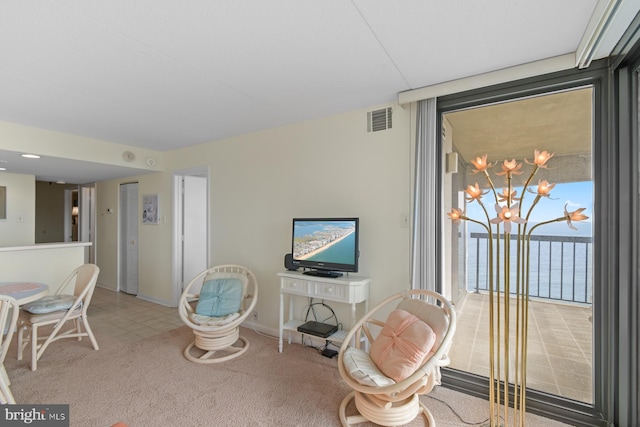 living area featuring an inviting chandelier, floor to ceiling windows, and carpet floors