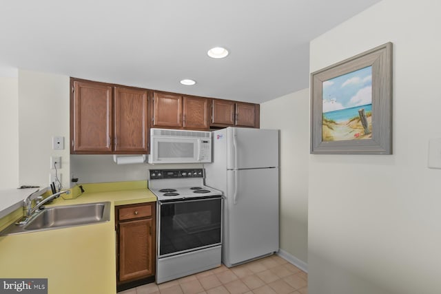 kitchen featuring white appliances, sink, and light tile patterned floors