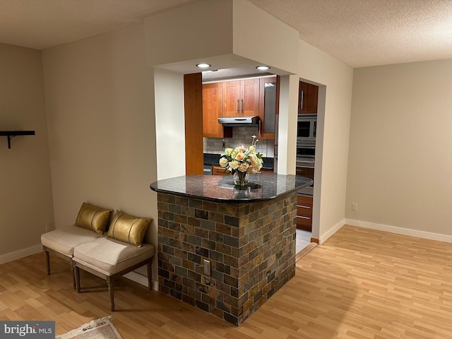 kitchen featuring backsplash, stainless steel appliances, and light hardwood / wood-style floors