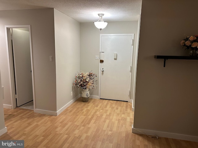 foyer featuring light hardwood / wood-style flooring and a textured ceiling