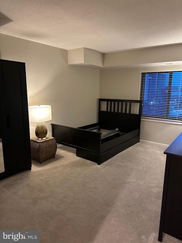 carpeted bedroom featuring a textured ceiling