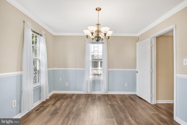 unfurnished dining area featuring crown molding, a chandelier, and dark hardwood / wood-style flooring