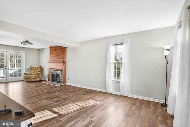 unfurnished living room featuring a fireplace, french doors, and hardwood / wood-style flooring