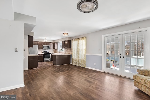 kitchen with appliances with stainless steel finishes, dark brown cabinetry, french doors, backsplash, and dark hardwood / wood-style floors