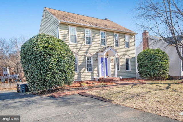 colonial home featuring a front lawn