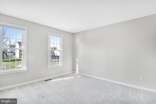 spare room featuring light colored carpet