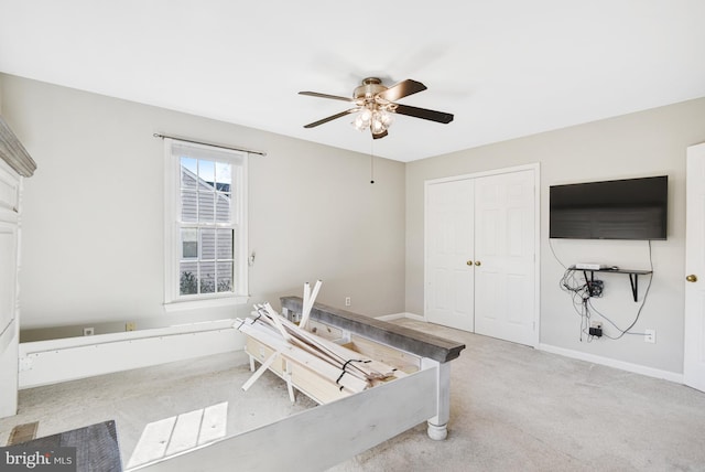 interior space featuring light carpet and ceiling fan