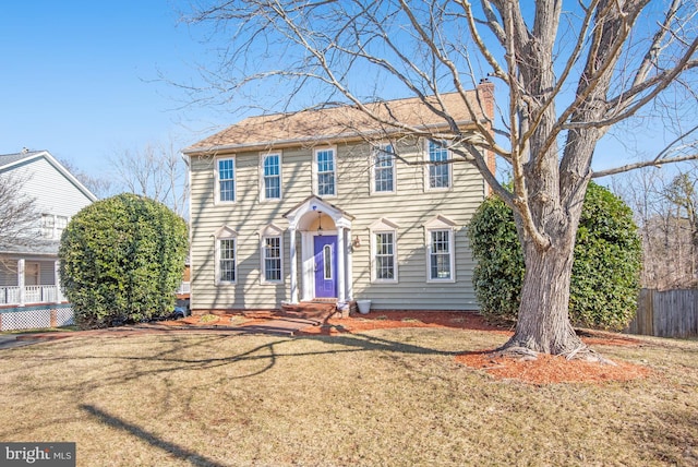 colonial-style house featuring a front lawn