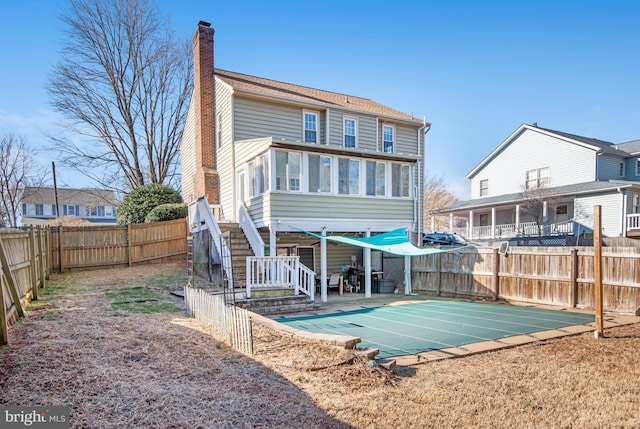 rear view of house featuring a patio area and a sunroom