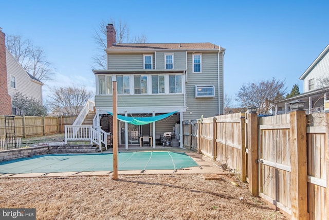 back of house featuring a covered pool and a patio area