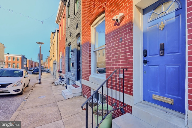 doorway to property featuring brick siding