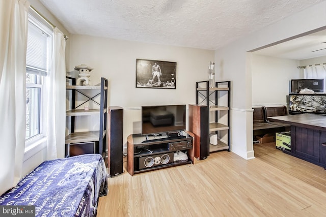 bedroom with hardwood / wood-style floors and a textured ceiling