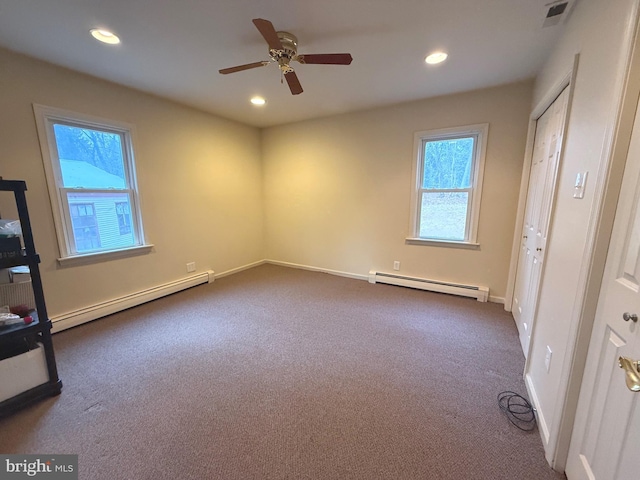 unfurnished bedroom with dark colored carpet and baseboard heating