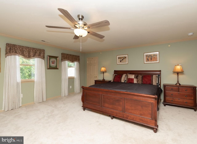 carpeted bedroom featuring crown molding and ceiling fan