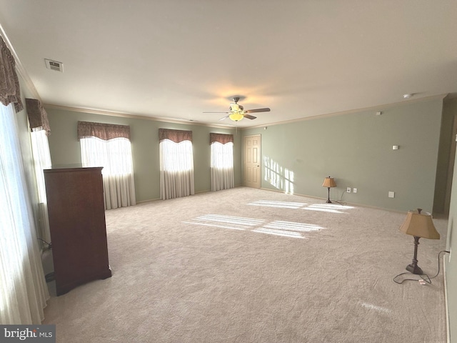 spare room with crown molding, ceiling fan, and light carpet