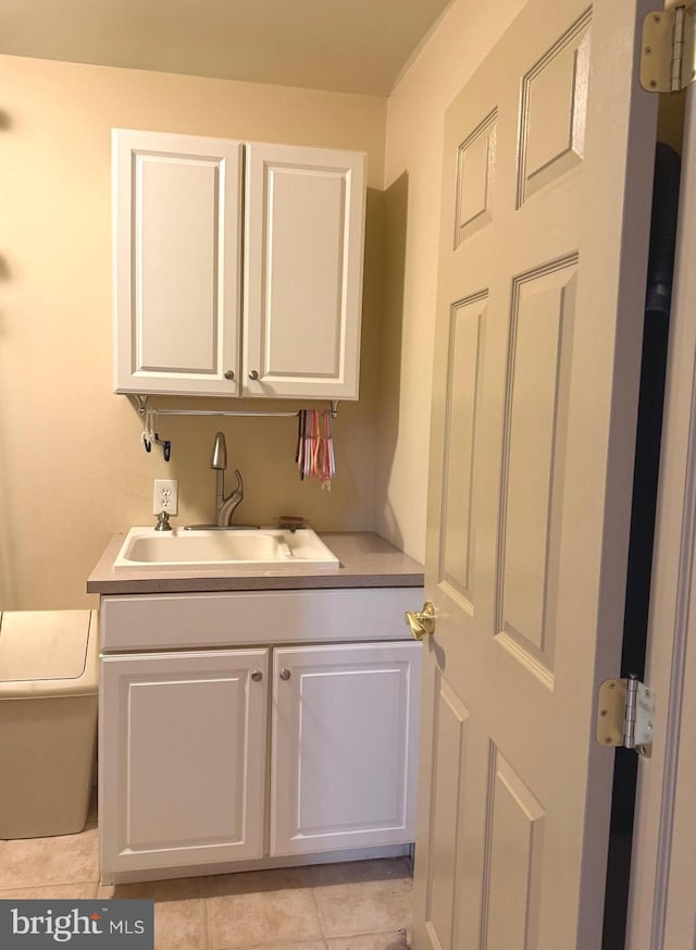 laundry area with light tile patterned flooring and sink