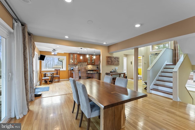 dining room featuring stairway, light wood-type flooring, and recessed lighting