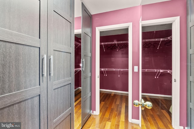 walk in closet with wood finished floors