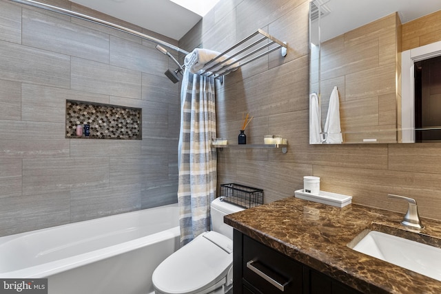 full bath featuring tasteful backsplash, toilet, shower / bath combination with curtain, vanity, and tile walls