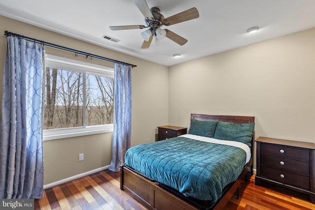 bedroom featuring a ceiling fan, baseboards, visible vents, and wood finished floors