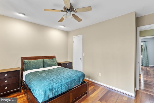 bedroom with light wood-type flooring, ceiling fan, and baseboards