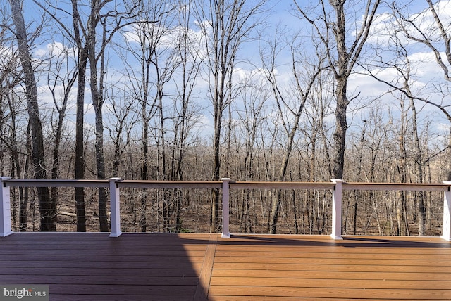 wooden terrace featuring a wooded view