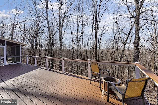 deck featuring an outdoor fire pit and a sunroom