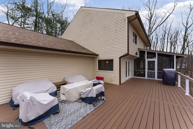 wooden terrace featuring a sunroom and a grill