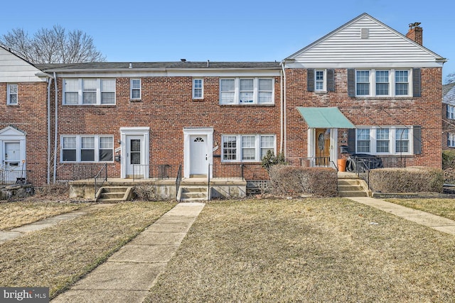 townhome / multi-family property featuring a front lawn