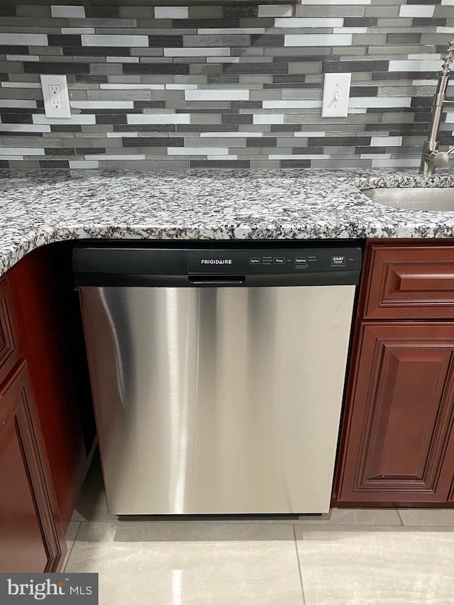 room details with light stone countertops, sink, stainless steel dishwasher, and backsplash