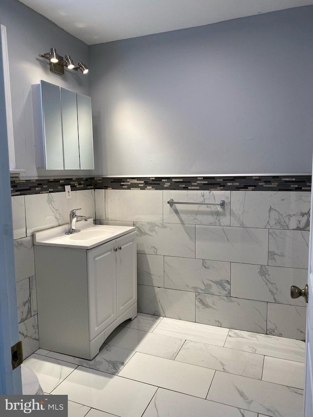 bathroom featuring vanity and tile walls