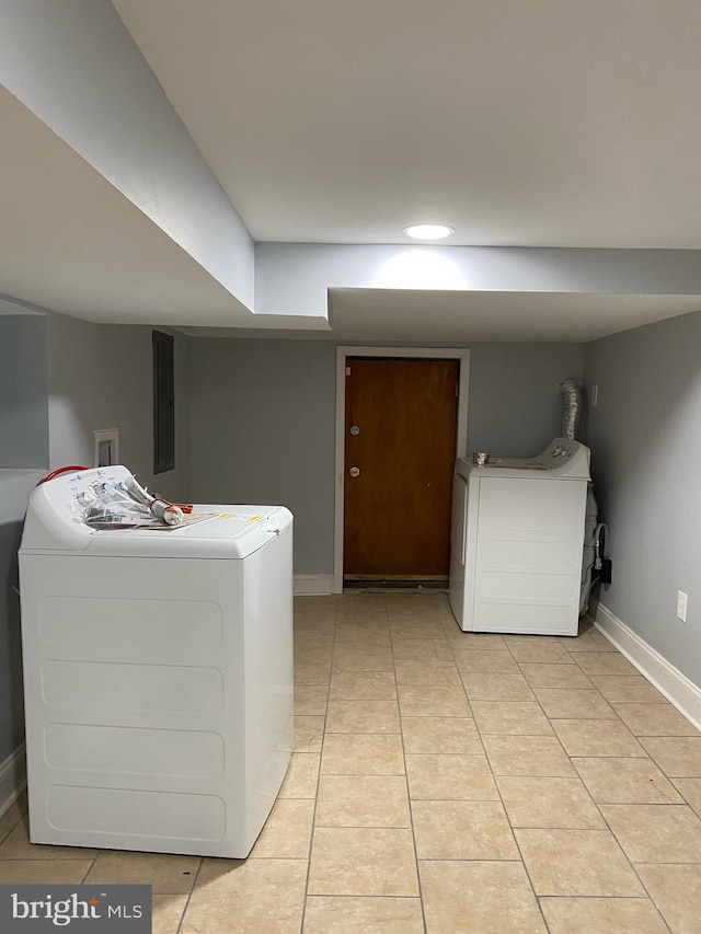 laundry room featuring light tile patterned floors, electric panel, and washing machine and clothes dryer