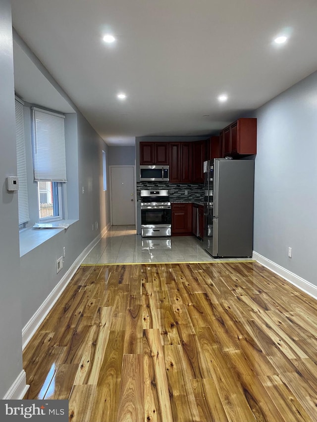 kitchen featuring stainless steel appliances, backsplash, and light hardwood / wood-style floors