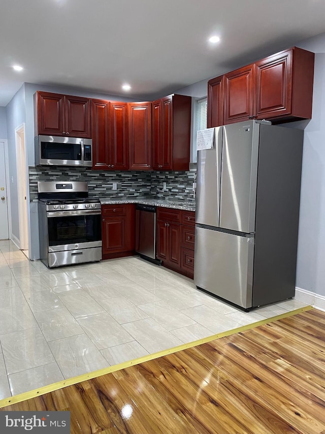 kitchen with tasteful backsplash and appliances with stainless steel finishes