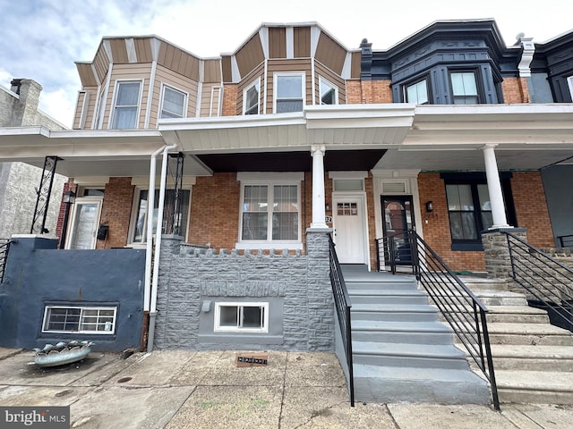 townhome / multi-family property featuring covered porch