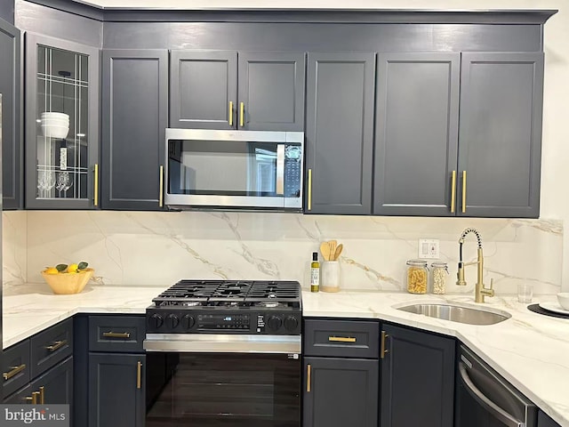 kitchen featuring sink, dishwasher, backsplash, light stone counters, and black range with gas stovetop