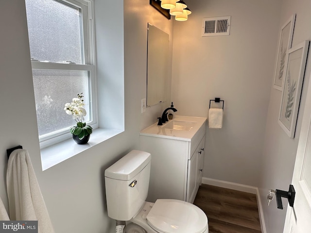 bathroom featuring vanity, hardwood / wood-style floors, and toilet