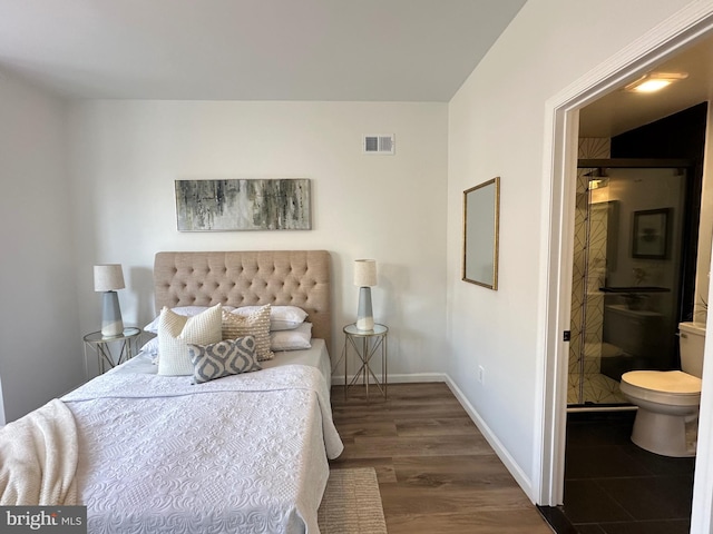 bedroom with ensuite bathroom and dark hardwood / wood-style floors