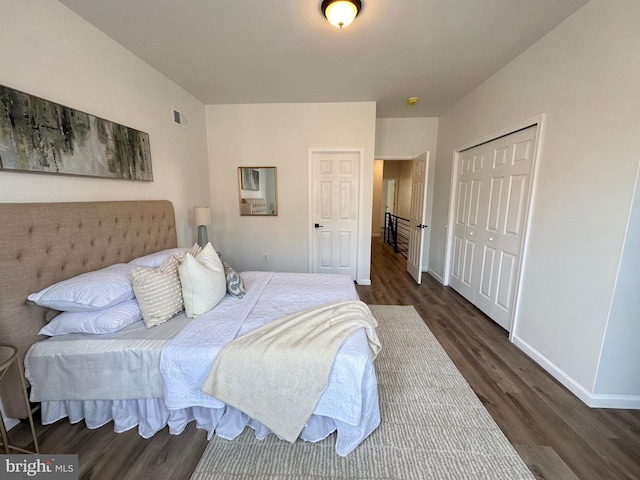 bedroom with dark hardwood / wood-style flooring and a closet