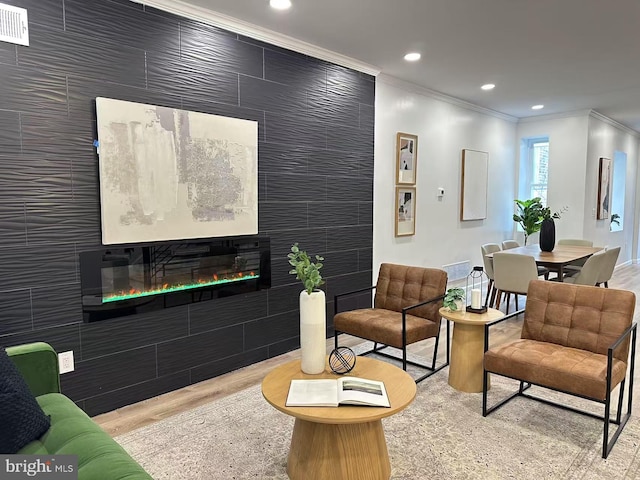 living room with crown molding and light hardwood / wood-style flooring