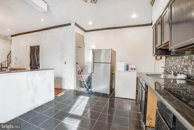 kitchen featuring sink, stainless steel fridge, dark tile patterned floors, backsplash, and oven