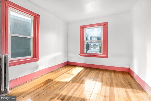 empty room featuring hardwood / wood-style flooring and radiator