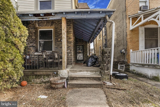 doorway to property with cooling unit and a porch