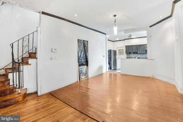 unfurnished living room featuring crown molding and light hardwood / wood-style flooring